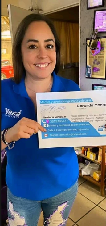 Persona sonriendo y sosteniendo la tarjeta de presentación de Montes y Asociados Gestoría Vehicular